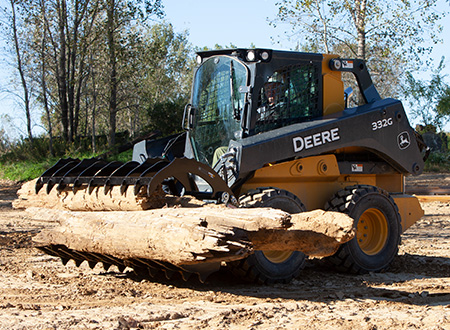 332G Skid Steer equipped with root rake attachment